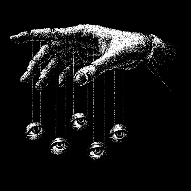 A hand dangling eyes from strings, like a marionette